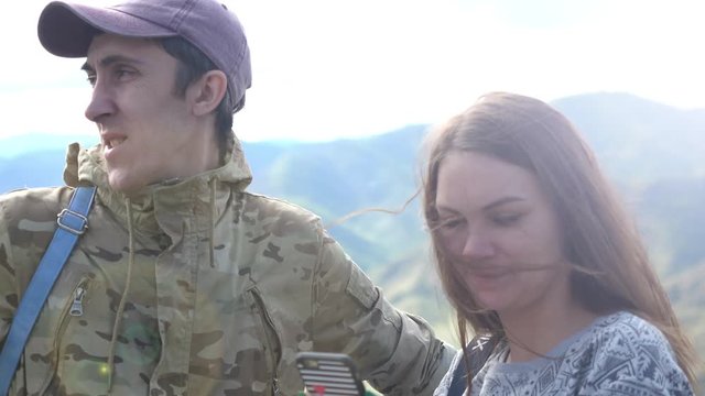 Happy couple on the mountain top taking selfie photo while kissing. 3840x2160