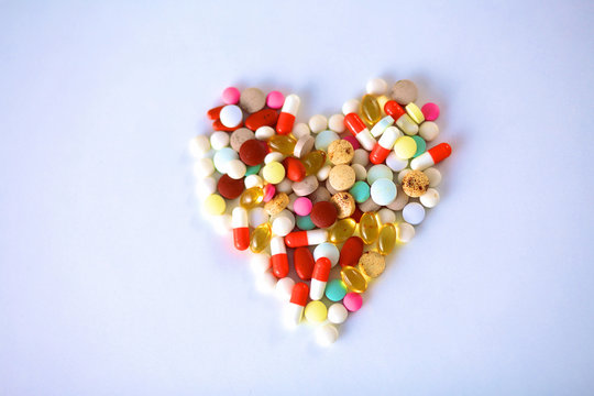 Stethoscope and some pills - isolated on a white background