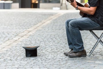 Fototapeta premium Zylinder Hut auf einem Kopfsteinpflaster und Straßenmusiker