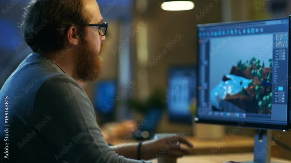 Poster male game developer works on a new level design. he's handsome bearded man with glasses and works in