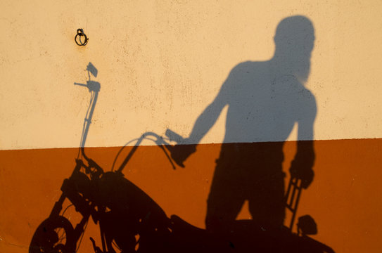 Shadow of a motorcyclist aged man
