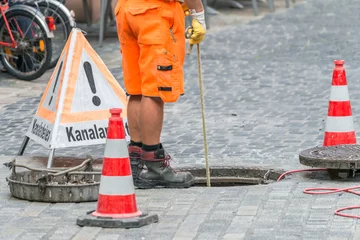 Foto auf Acrylglas Kanal Straßenarbeiter bei Kanalarbeiten