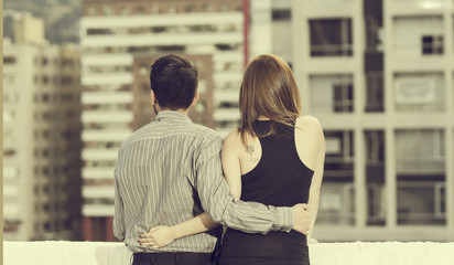 Beautiful young couple hugging in a blurred background, back view, vintage effect