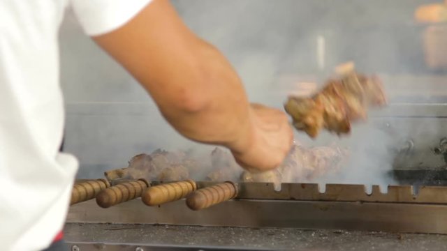 Hands of professional cook making a shish kebab (shashlik).