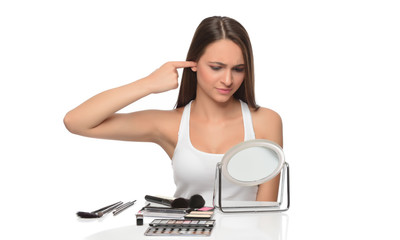  A young woman applying makeup on her face with a brush