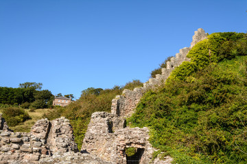 Fototapeta na wymiar Green hill with old stone ruins