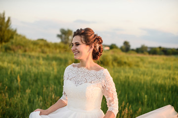 Fototapeta na wymiar happy bride On the meadow near the forest on wedding day