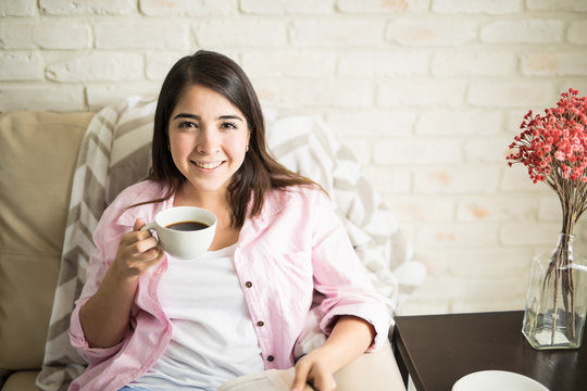 Woman drinking coffee in her apartment
