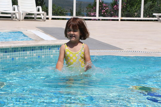 Little girl playign in the pool