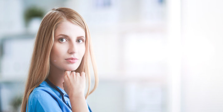 Doctor woman is standing in the near window