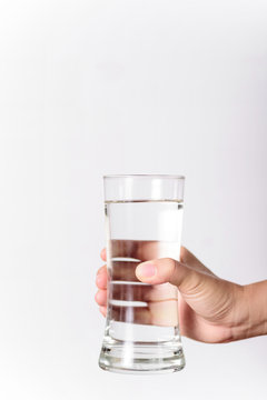The hands of a beautiful woman holding a glass of water on a white background.