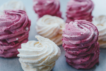 White mango and pink blueberry marshmallows or zephyr with sugar powder on a table. Homemade sweet.