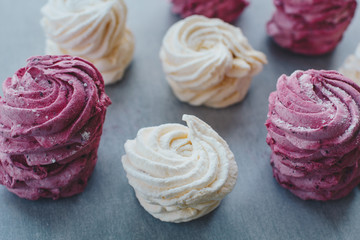 White mango and pink blueberry marshmallows or zephyr with sugar powder on a table. Homemade sweet.