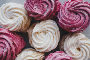 White mango and pink blueberry marshmallows or zephyr with sugar powder on a table. Homemade sweet.