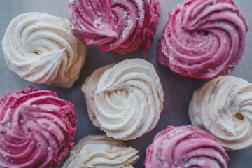 White mango and pink blueberry marshmallows or zephyr with sugar powder on a table. Homemade sweet.