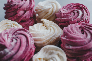 White mango and pink blueberry marshmallows or zephyr with sugar powder on a table. Homemade sweet.