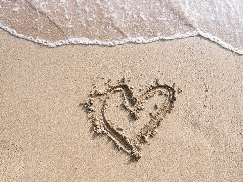 Summer vacation on sandy ocean beach, Summertime Lifestyle objects flat lay top view .Concept summer love  time.Write love heart on the beach.