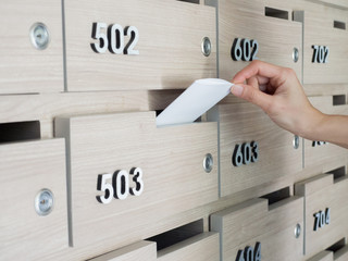 Close-up of person's hand . hand removing a letter from mailbox in the entrance hall of an...