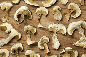 Dry boletus mushrooms on wooden table, background.