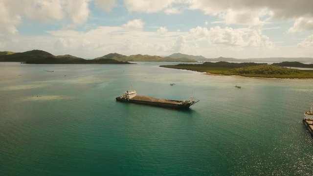 Cargo and passenger port with barges and cargo ships on tropical island. Aerial view:passenger ferry terminal Dapa city .Ferries for transport vehicles and passengers in the port. Philippines, Siargao