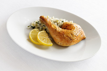 roasted with basil, black pepper and garlic chicken leg garnished with lemon slices and rice with leek and chard