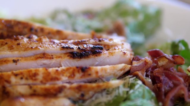 Motion of avocado chicken caesar salad on plate inside Denny's restaurant 