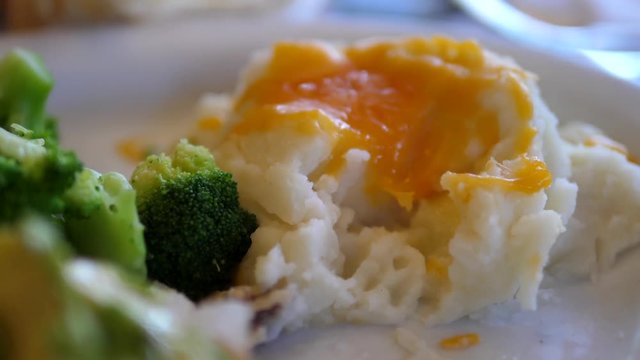 Motion of people eating potato on plate inside Denny's restaurant