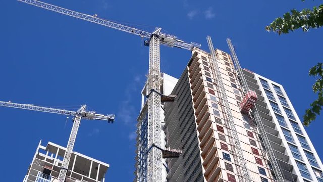 Motion of modern high rise building with construction crane 