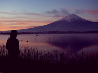 silhouette view from 25s to 35s man see sunrise from kawaguchi lake and fuji mountain background from japan