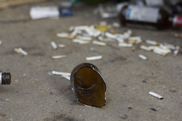 broken bottles and cigarette butts on the ground