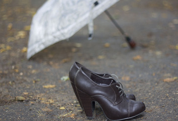 umbrella and autumn women's shoes on the road