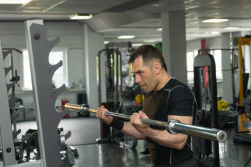 Strong man exercising with a barbell in a gym