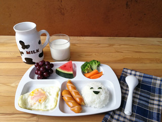 Creative morning breakfast and milk for kids before go to school on wooden table with copy space. Kid meal concept. 