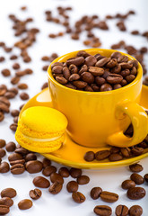 Cup of coffee and beans with delicious macaroon on a white background.
