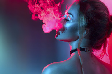 Fashion art portrait of beauty model woman in bright lights with colorful smoke. Smoking girl - obrazy, fototapety, plakaty