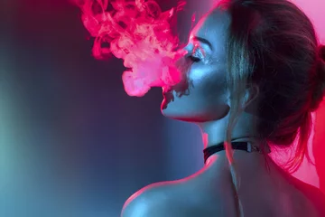 Foto op Plexiglas Vrouwen Mode kunst portret van schoonheid model vrouw in felle lichten met kleurrijke rook. Rokend meisje