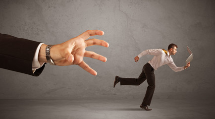 Businessman running from hand