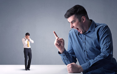 Young businessman fighting with miniature businessman