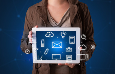 Woman holding tablet with media graphics