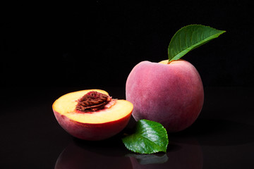 Fototapeta na wymiar Peaches on Black Shiny Background