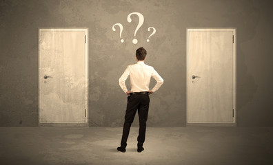 Obraz premium Businessman standing in front of doors