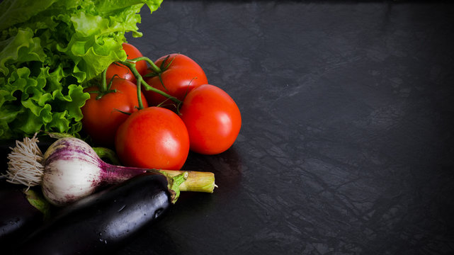 fresh, ripe vegetables lay the table on a dark background