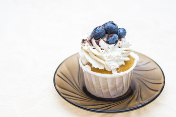cake with cream and blueberries on a glass plate