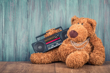 Retro Teddy Bear toy and old outdated ghetto blaster radio recorder from 80s front grunge wooden...