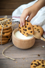 Honey cookies with raisins and milk on wooden table