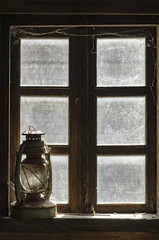 Old wooden window and vintage kerosene oil lantern lamp