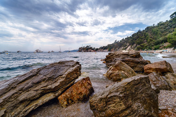 rocky sea shore with pebble beach, waves , dramatic clouds