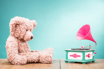 Teddy Bear toy sitting at the wooden floor with retro gramophone front gradient aquamarine...