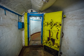 Yellow hermetic metal armored door, entrance of soviet military bunker 
