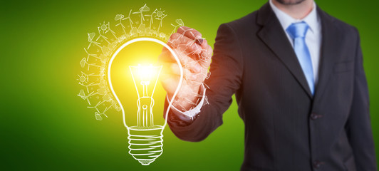 Businessman drawing renewable eco lightbulb sketch